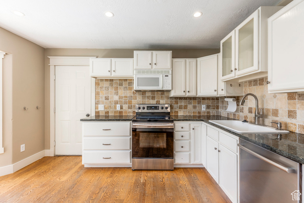 Kitchen with stainless steel appliances, tasteful backsplash, white cabinetry, and recessed lighting