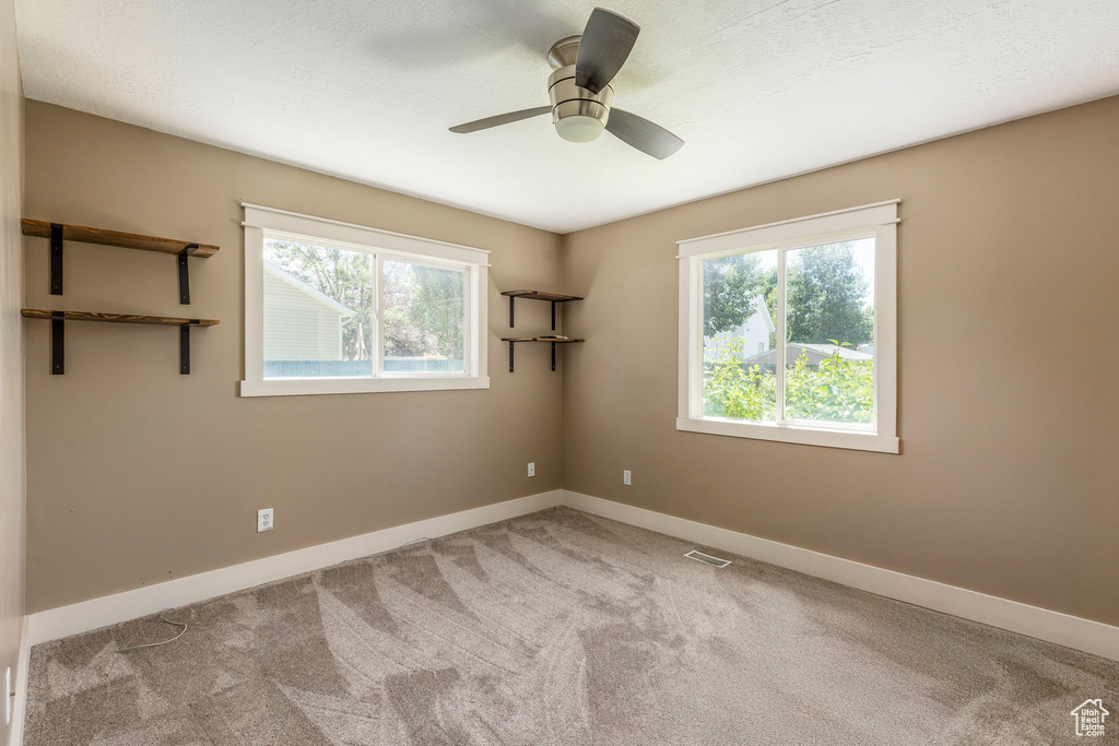 Empty room featuring carpet flooring and ceiling fan