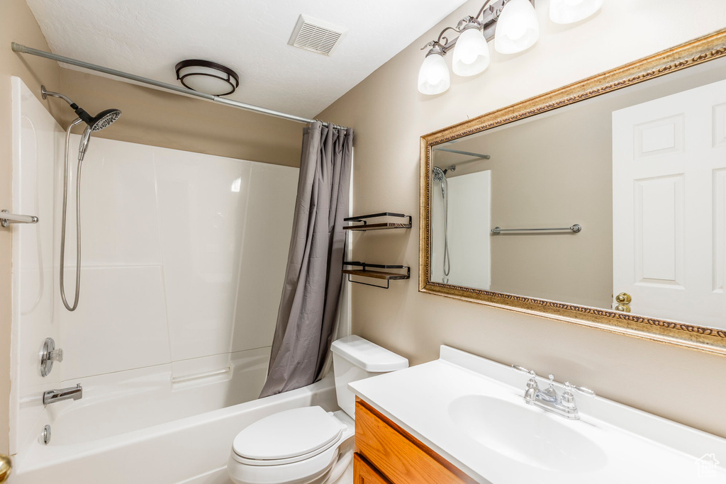 Full bath with shower / bath combo with shower curtain and vanity
