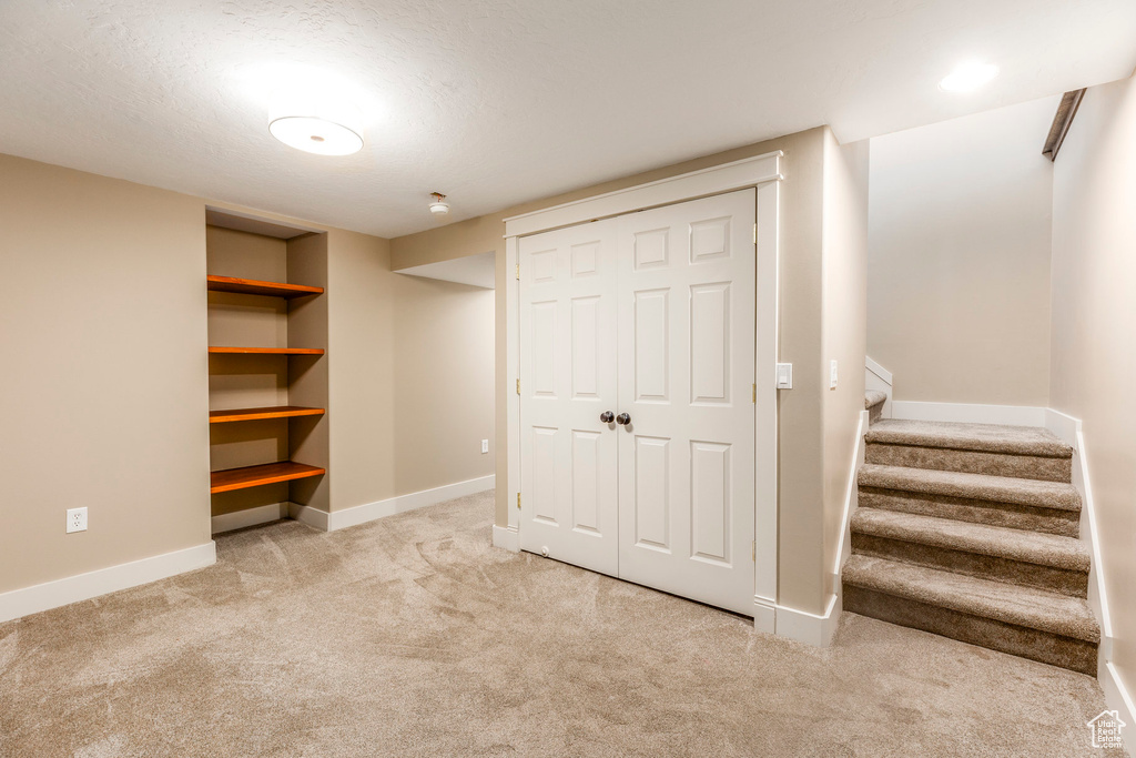 Finished basement with carpet floors and stairs