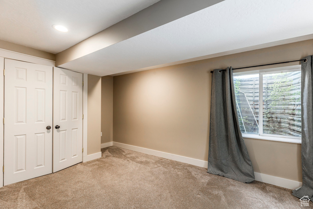 Unfurnished bedroom with light colored carpet, a closet, and recessed lighting