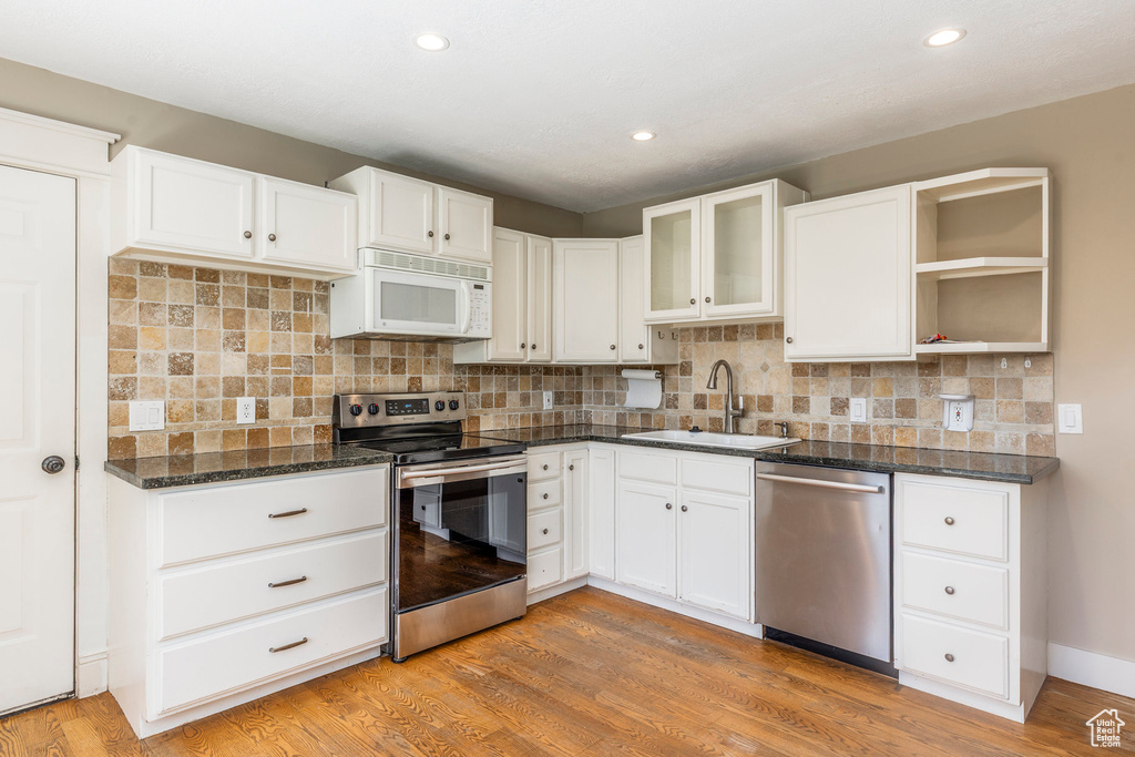 Kitchen featuring stainless steel appliances, white cabinetry, light wood finished floors, and recessed lighting