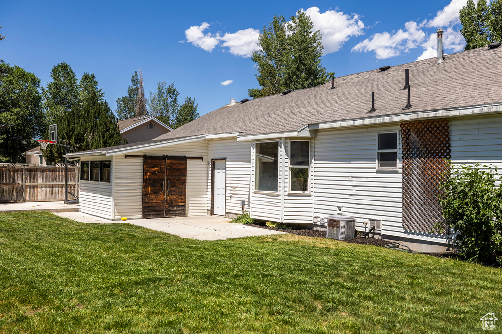 Rear view of property with a patio area and roof with shingles