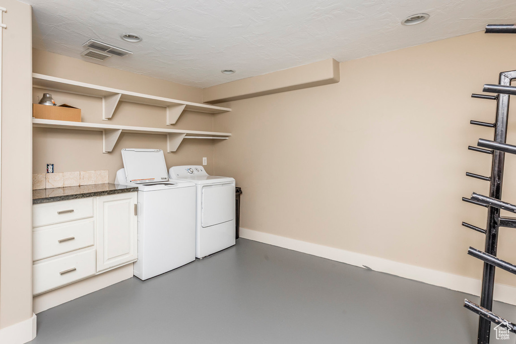 Laundry room featuring independent washer and dryer, cabinet space, and recessed lighting