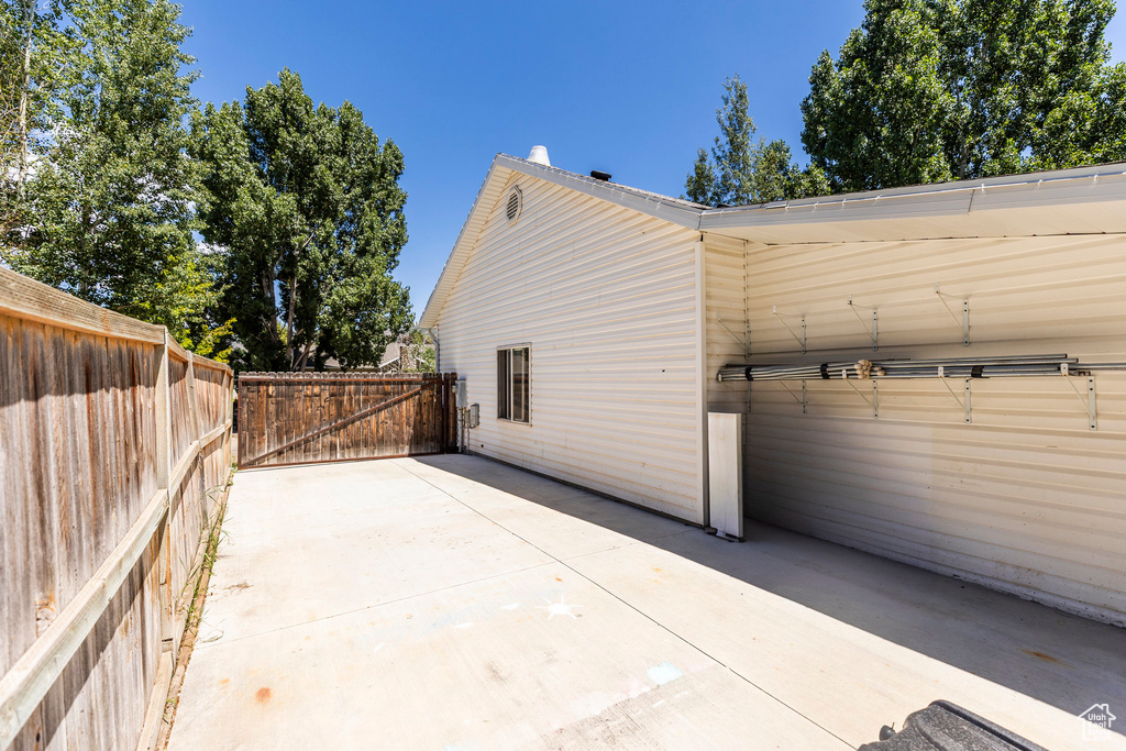 View of side of home with a patio area and driveway