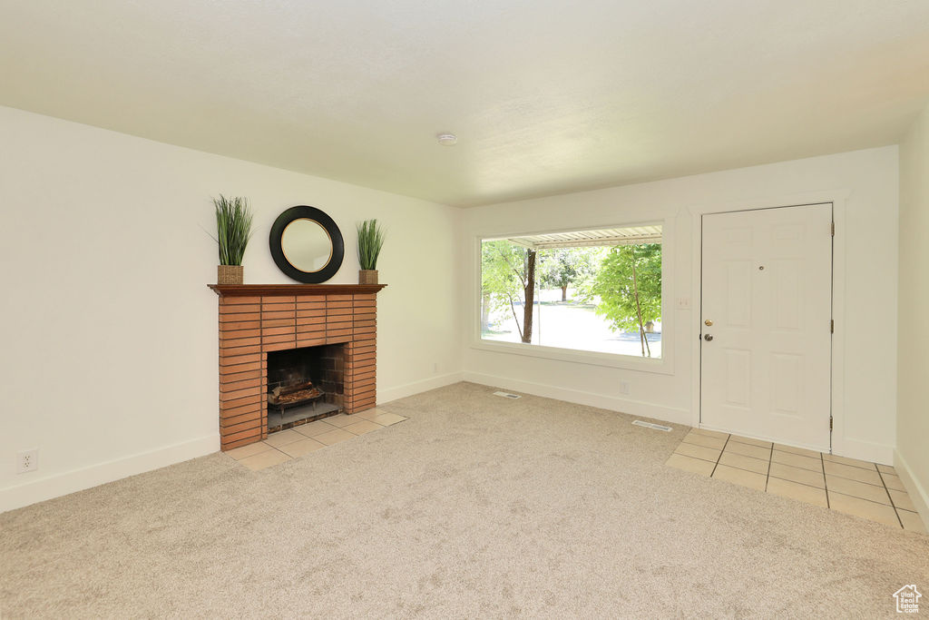 Unfurnished living room featuring carpet flooring and a fireplace