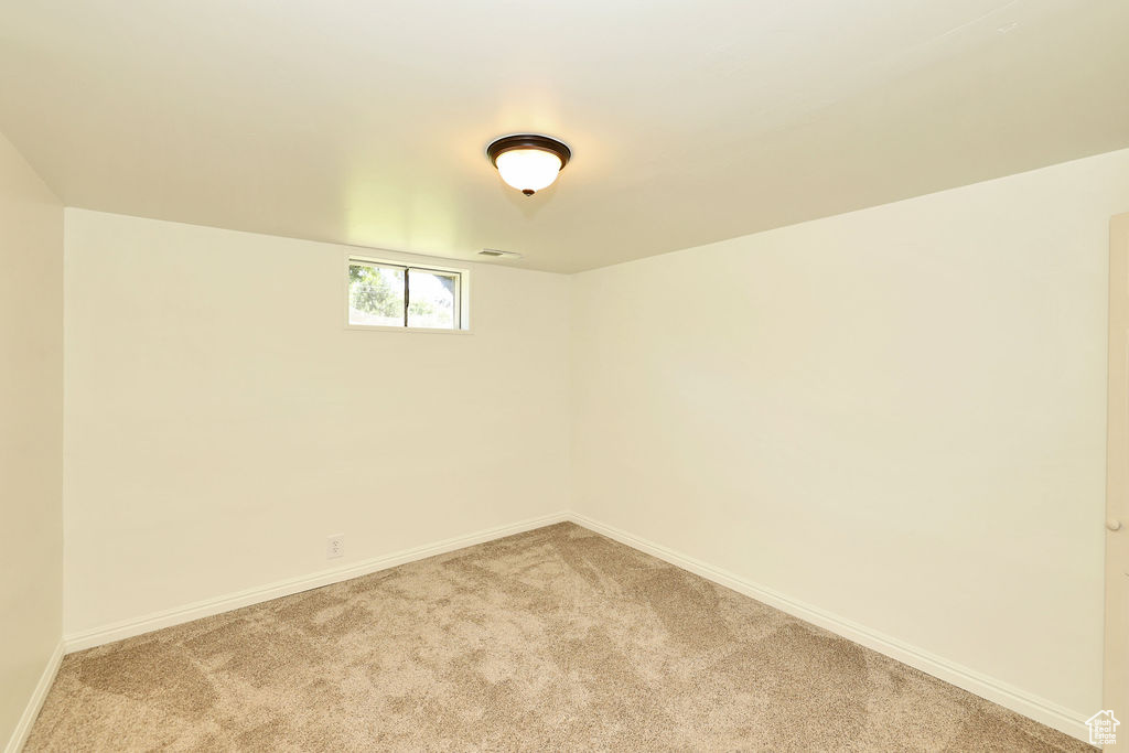 Spare room with light carpet and baseboards