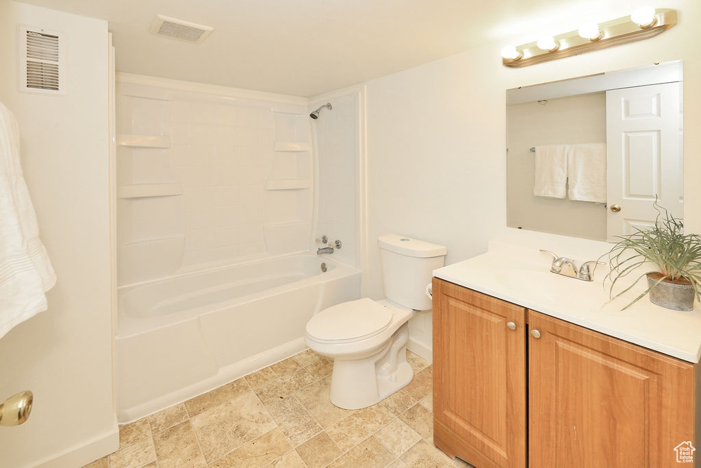 Bathroom featuring vanity, shower / bath combination, and stone finish flooring
