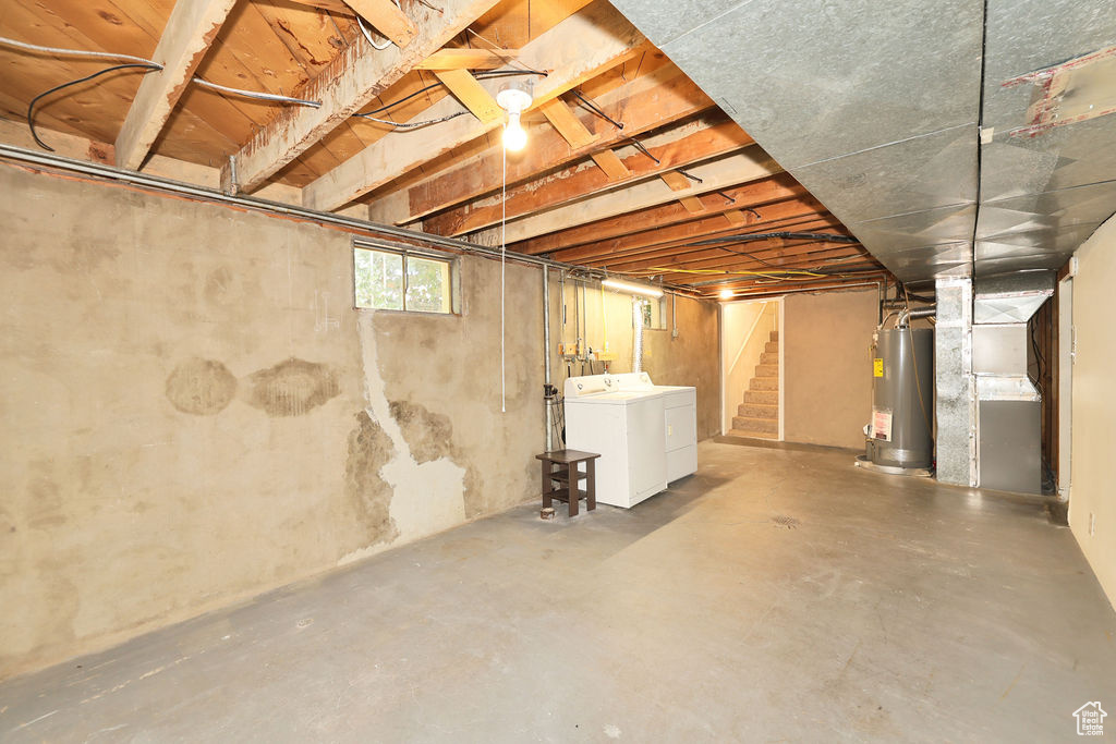Below grade area with gas water heater, independent washer and dryer, and stairs