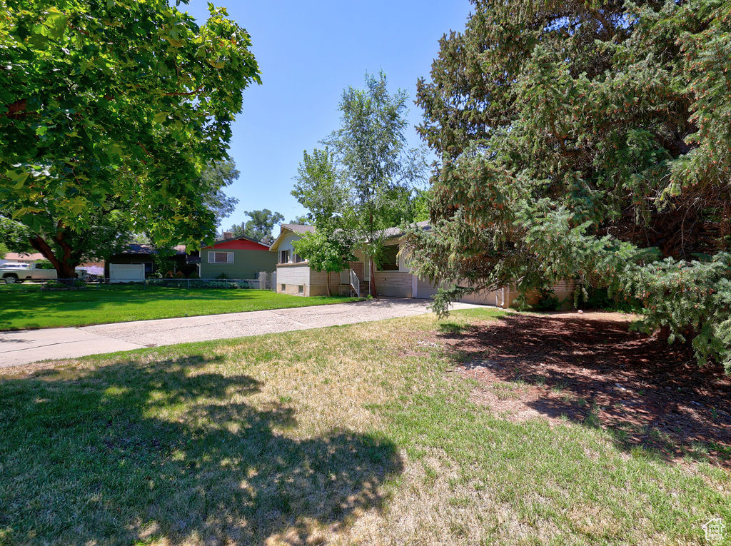 View of front of home with a front yard and driveway