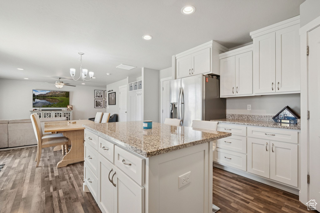 Kitchen with stainless steel fridge with ice dispenser, a chandelier, dark wood-style floors, a kitchen island, and white cabinetry