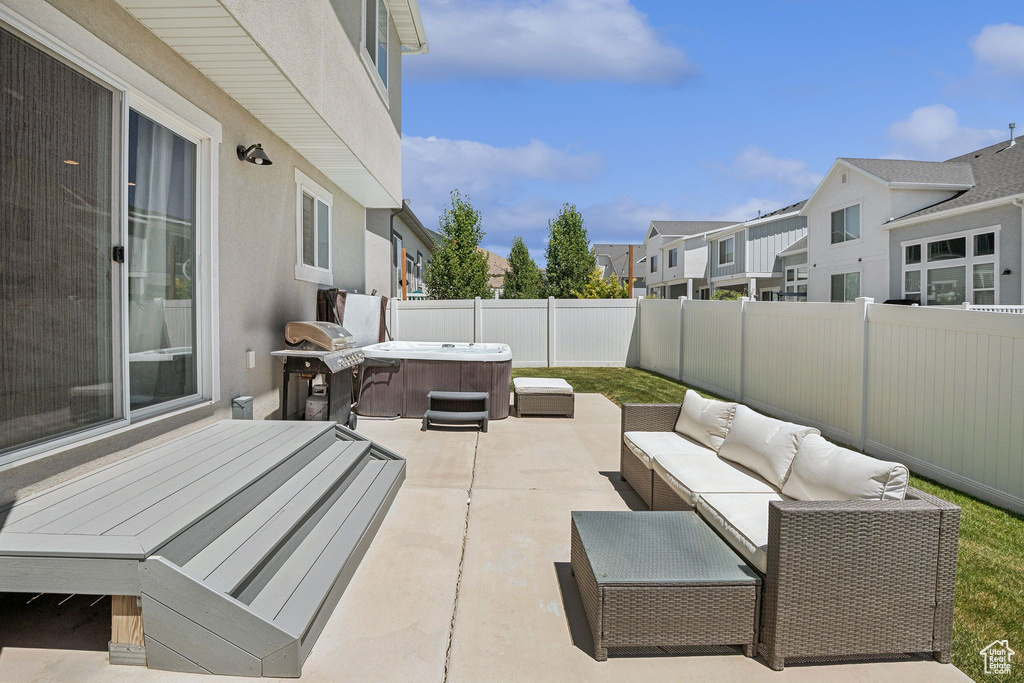 Fenced backyard with a hot tub, a patio, a residential view, an outdoor hangout area, and area for grilling