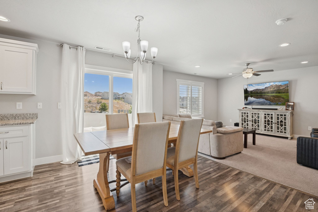 Dining space with dark wood-style flooring, recessed lighting, a chandelier, and ceiling fan