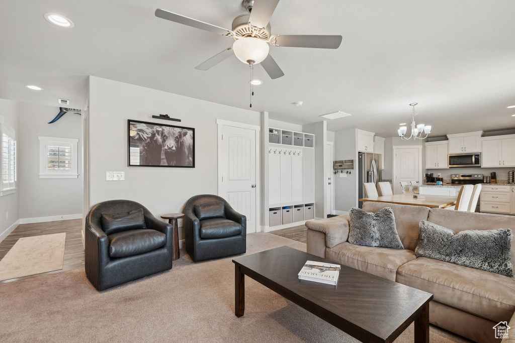 Living room with a chandelier, recessed lighting, and a ceiling fan