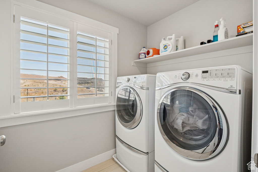 Laundry area with independent washer and dryer and baseboards