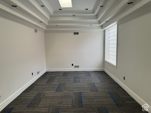 Empty room featuring a tray ceiling, carpet floors, and ornamental molding