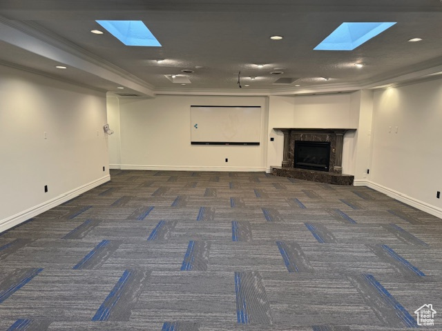 Unfurnished living room featuring a skylight, carpet floors, a high end fireplace, and recessed lighting