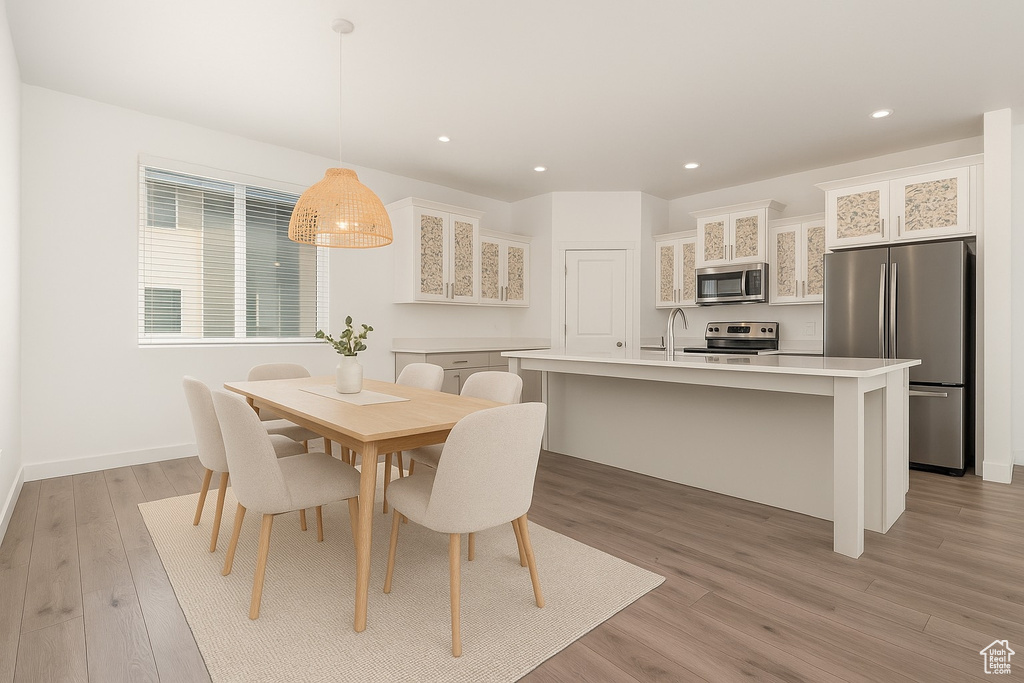 Dining area featuring light wood finished floors and recessed lighting