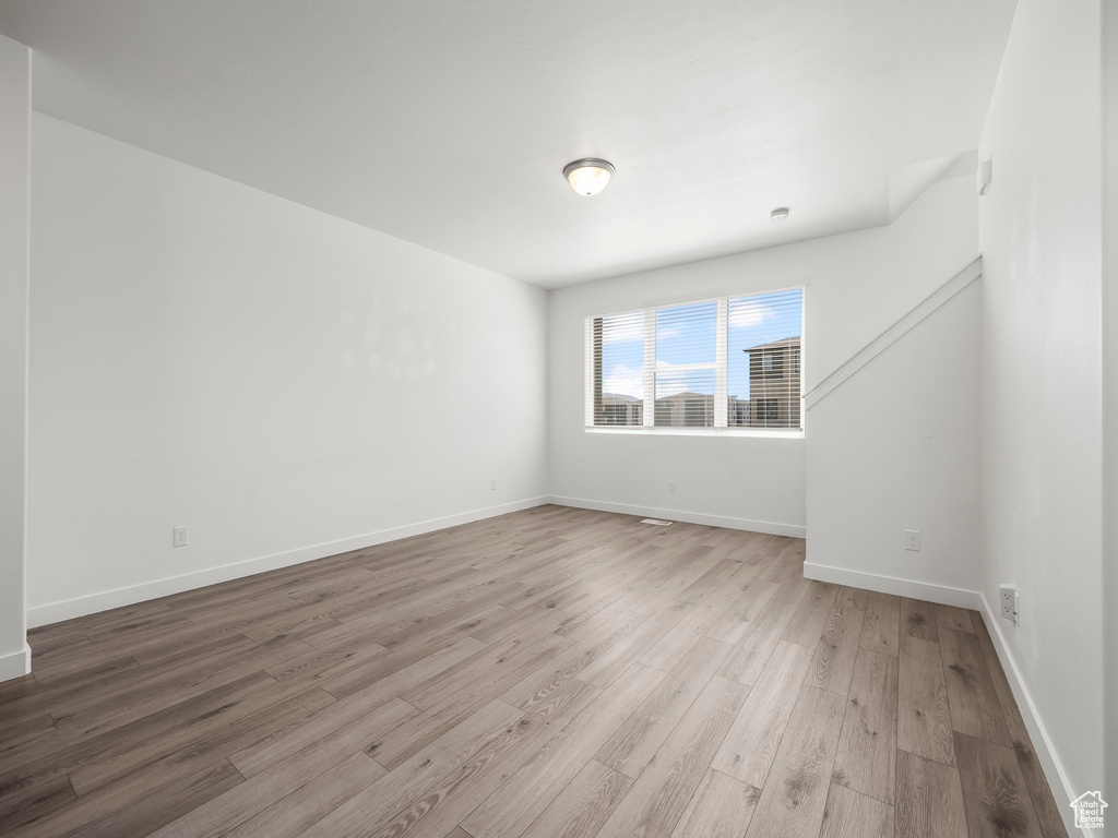 Unfurnished room with wood finished floors and baseboards