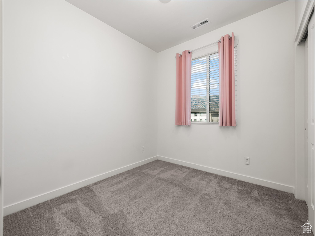 Empty room featuring carpet floors and baseboards