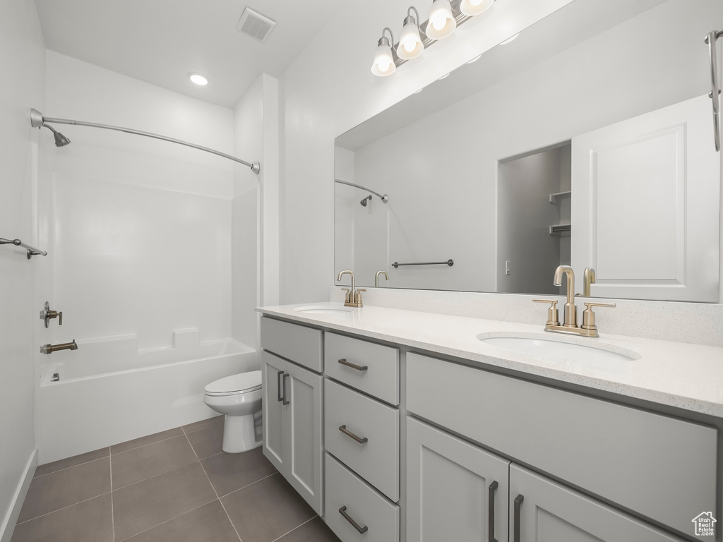 Bathroom with double vanity, shower / washtub combination, and tile patterned floors