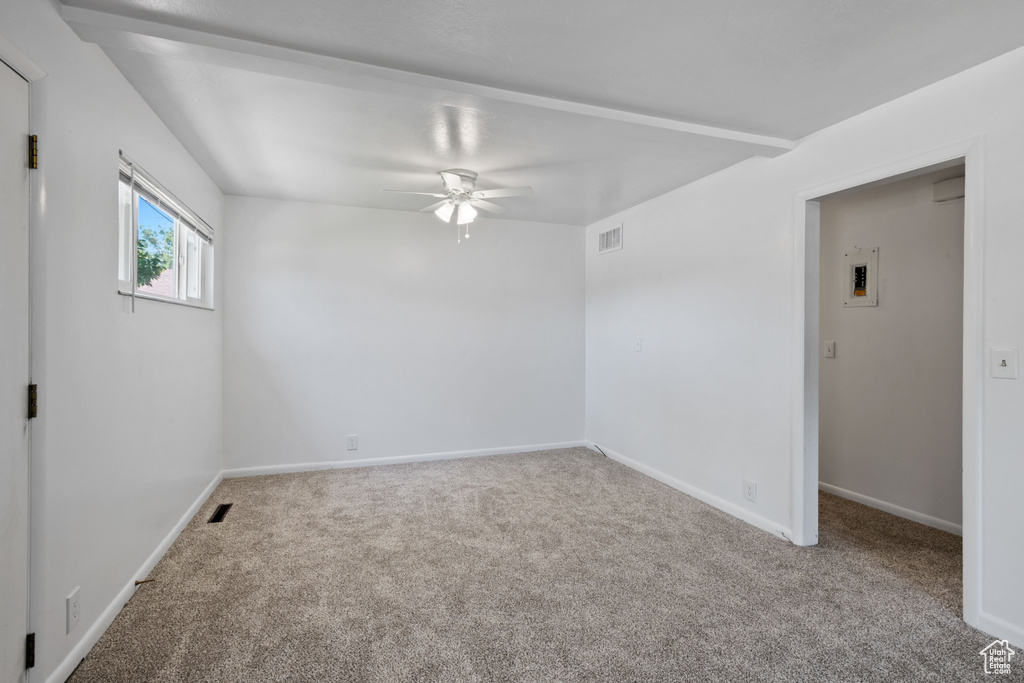 Carpeted empty room featuring ceiling fan and baseboards