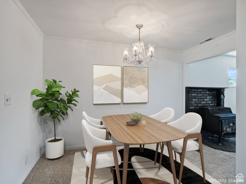 Dining room featuring a chandelier, ornamental molding, a wood stove, and carpet floors