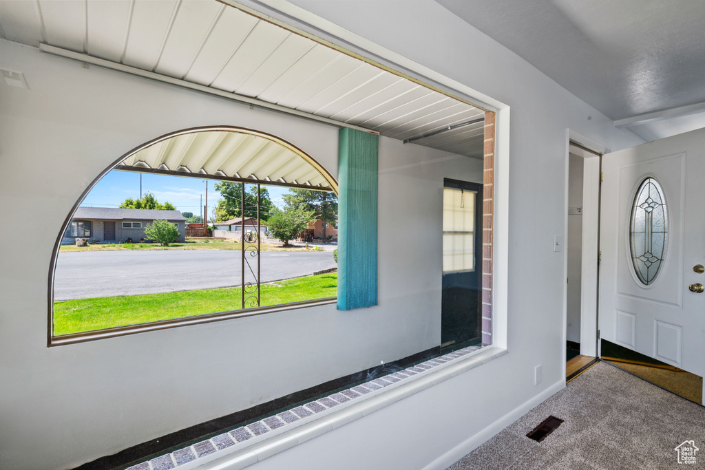 Carpeted foyer featuring baseboards