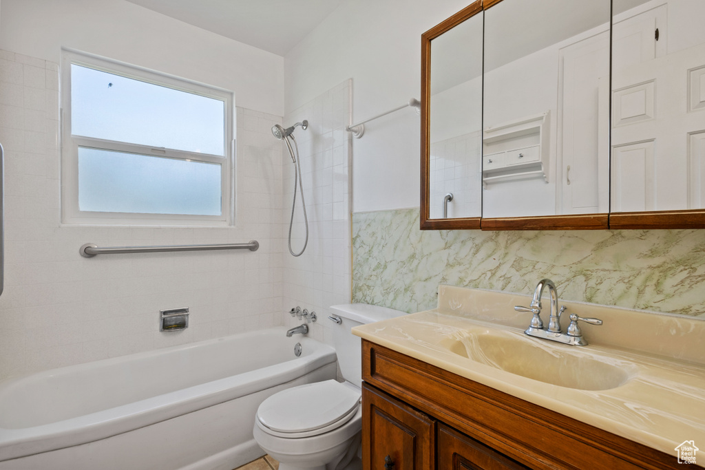 Full bath with vanity, tub / shower combination, and tasteful backsplash