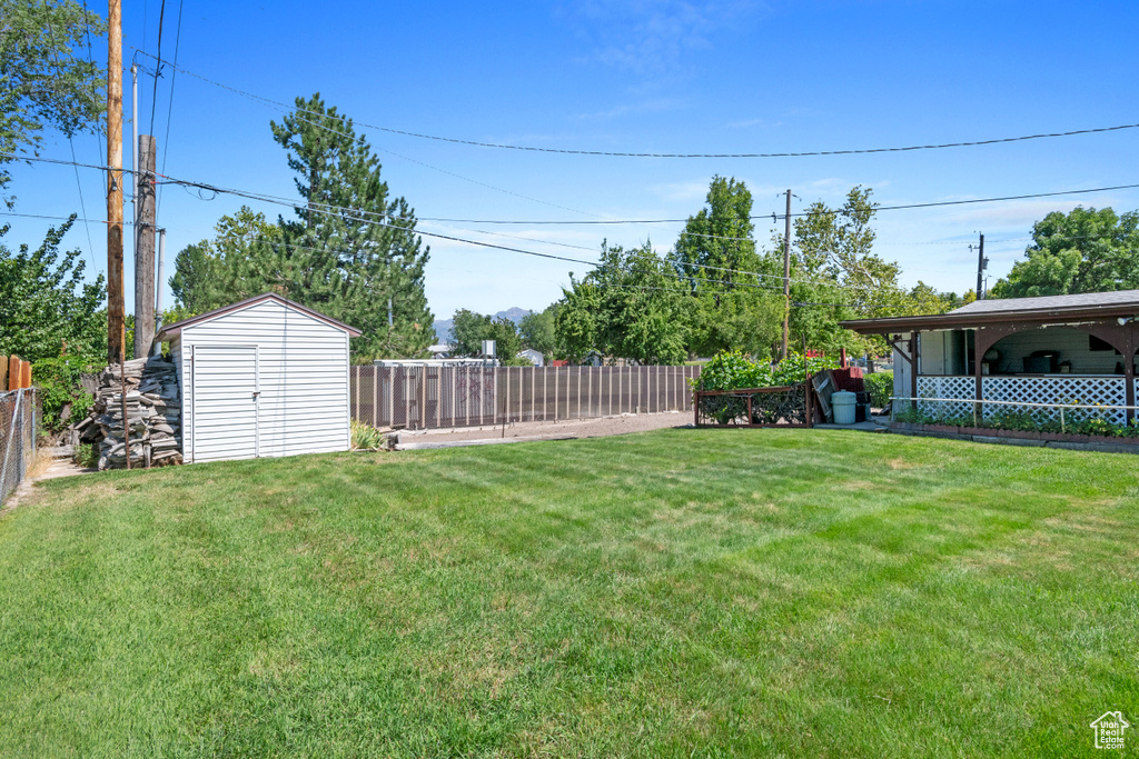 Fenced backyard featuring a storage shed