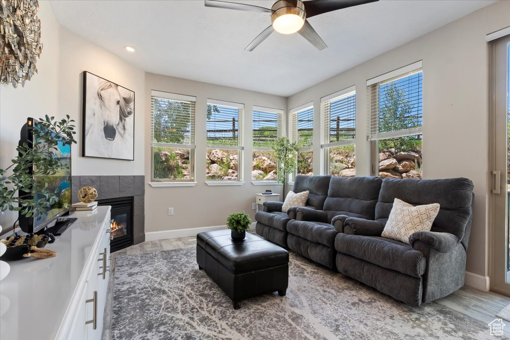 Living area featuring ceiling fan, wood finished floors, a tile fireplace, and recessed lighting