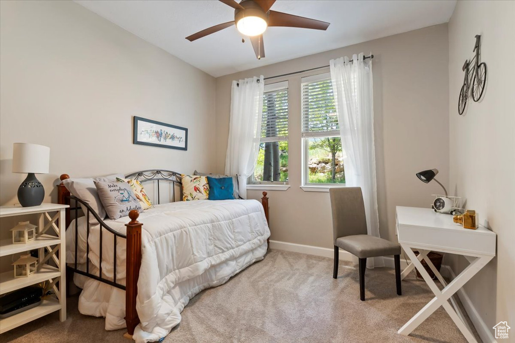 Carpeted bedroom featuring baseboards and ceiling fan