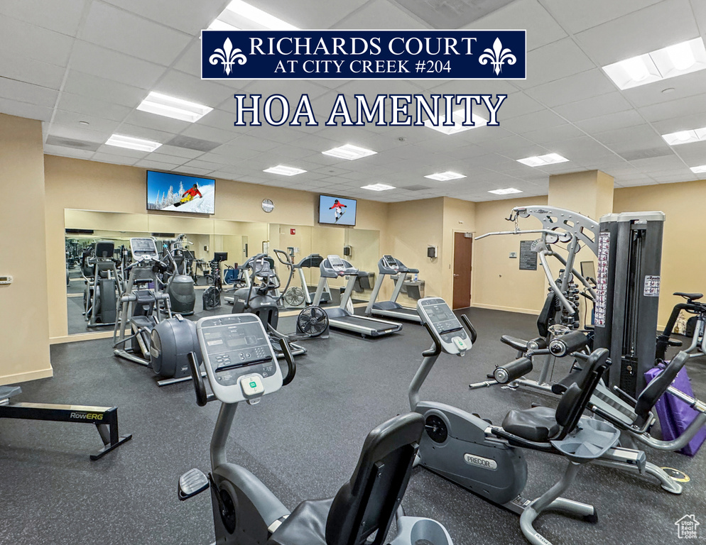 Exercise room featuring a drop ceiling and baseboards