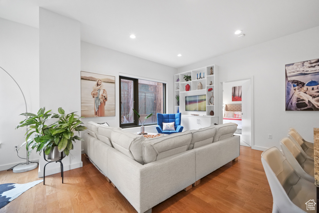 Living room with light wood-style flooring and recessed lighting