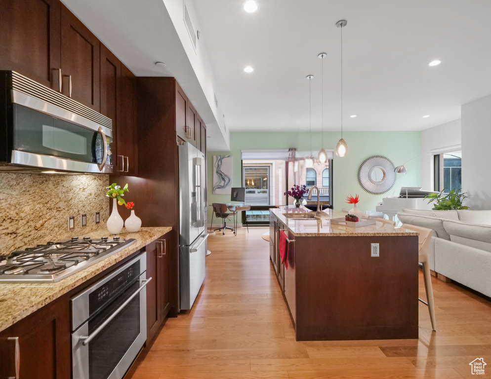 Kitchen featuring stainless steel appliances, healthy amount of natural light, backsplash, decorative light fixtures, and recessed lighting