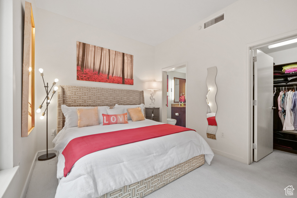 Bedroom with a walk in closet and carpet floors