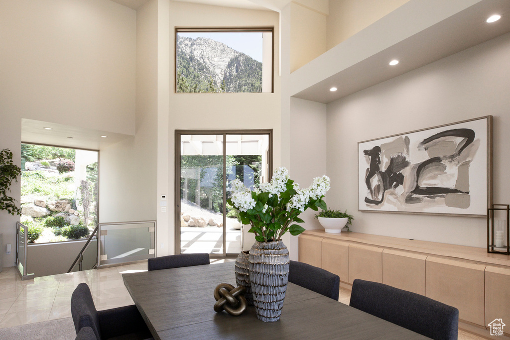 Dining area with a towering ceiling, plenty of natural light, recessed lighting, and a mountain view