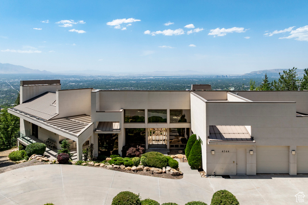 View of front of house featuring a standing seam roof, a mountain view, a metal roof, and concrete driveway