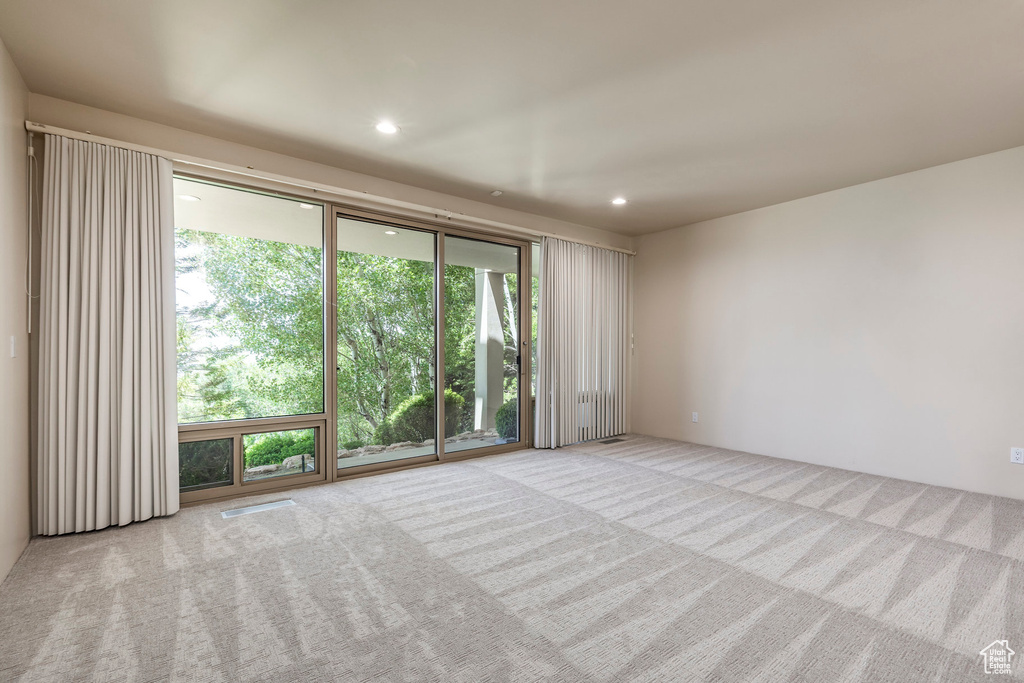 Spare room featuring carpet floors, plenty of natural light, and recessed lighting