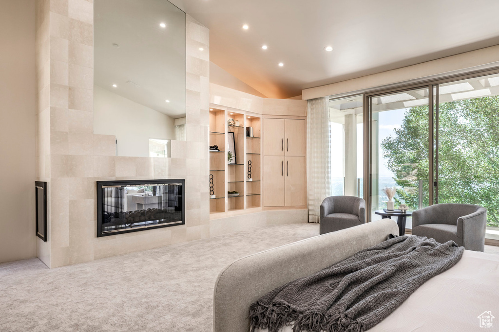 Carpeted bedroom with lofted ceiling, recessed lighting, a fireplace, and access to exterior