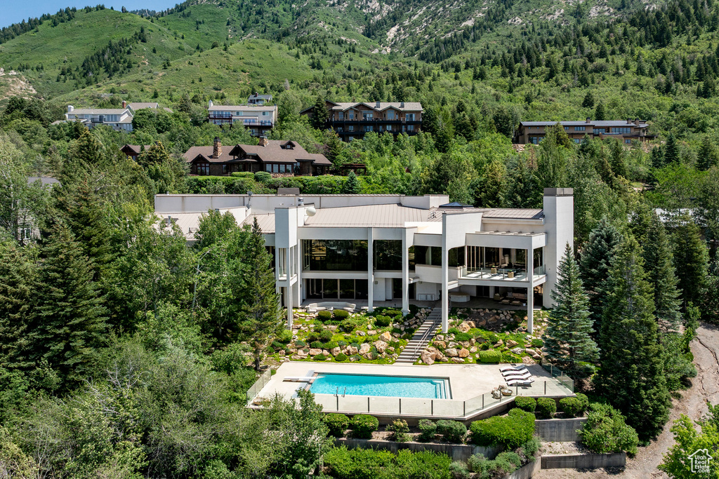 View of subject property with a heavily wooded area and mountains