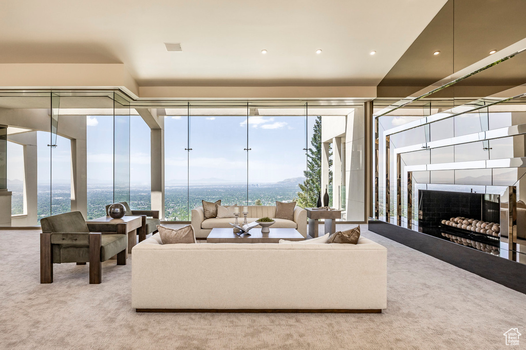 Carpeted living area featuring expansive windows, a water view, and a fireplace