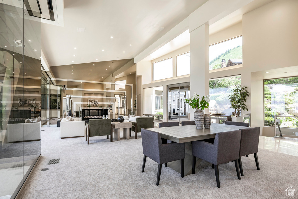 Carpeted dining room featuring a towering ceiling and recessed lighting