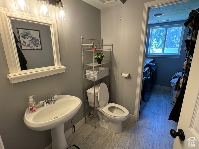Bathroom with washing machine and dryer and marble look tiles