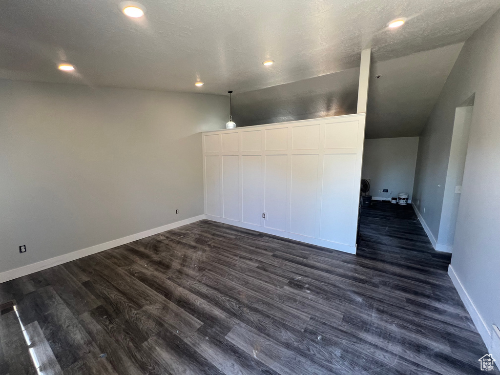 Unfurnished room with vaulted ceiling, dark wood-style flooring, and recessed lighting