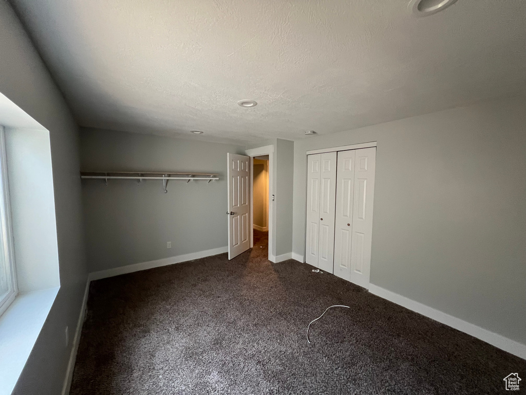 Unfurnished bedroom with a closet, carpet floors, recessed lighting, and a textured ceiling