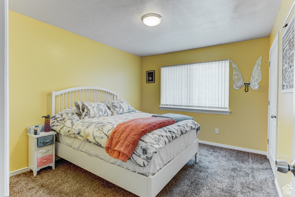 Bedroom featuring carpet and a textured ceiling