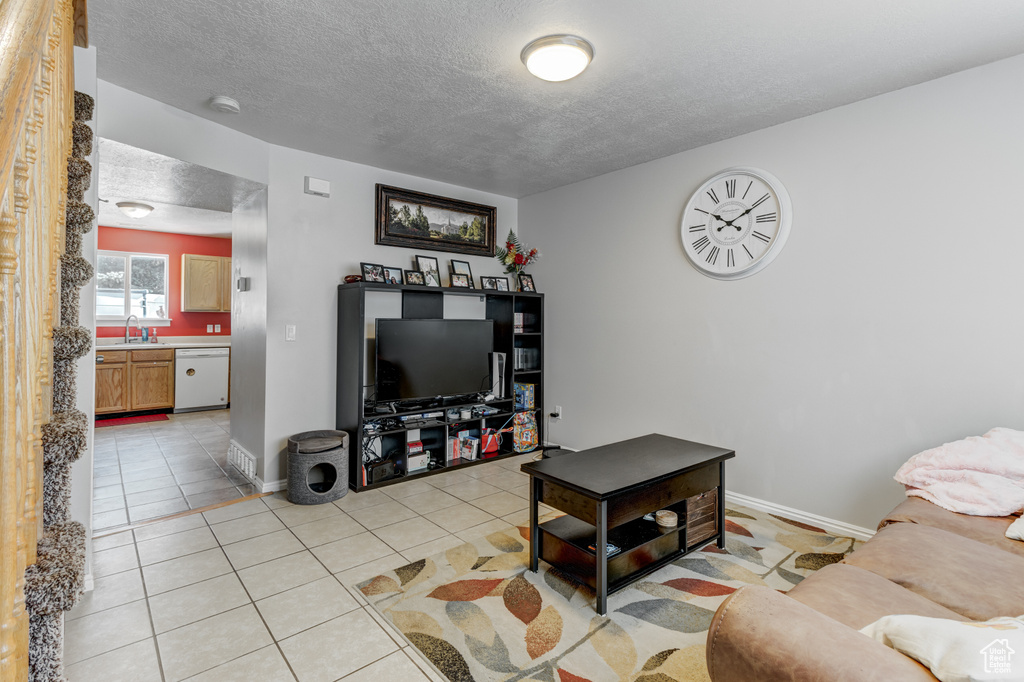 Living room featuring a textured ceiling and light tile patterned flooring