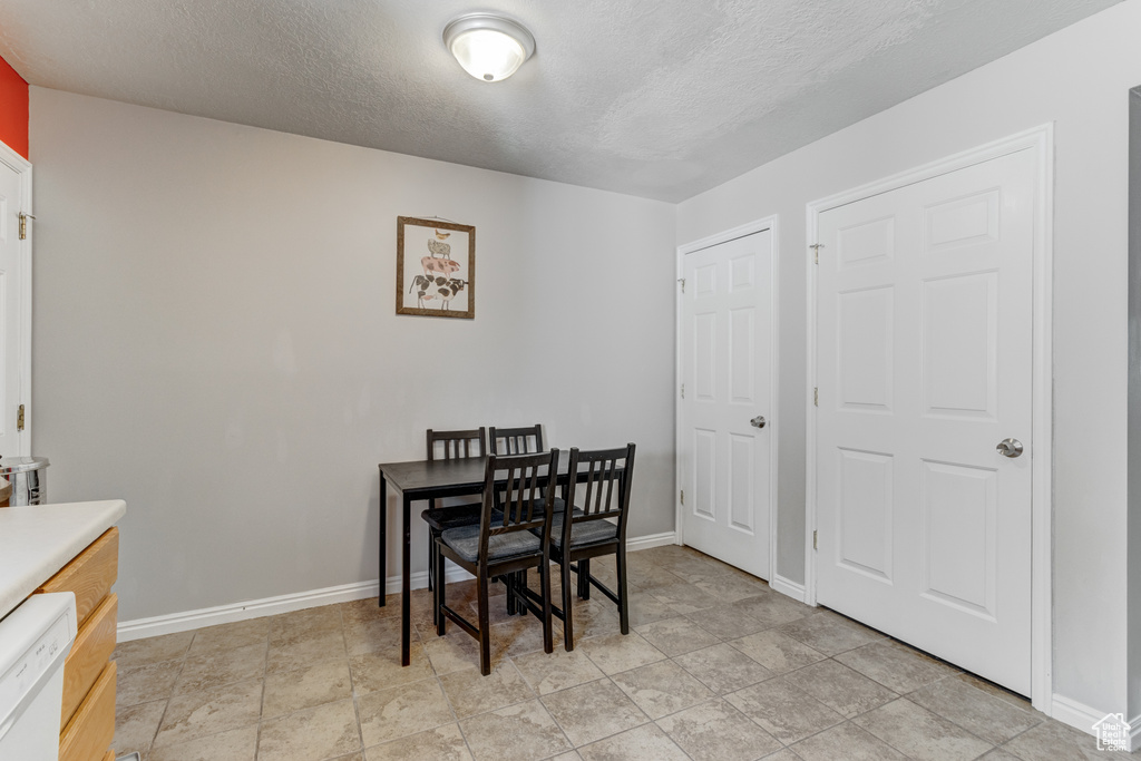 Dining space featuring a textured ceiling and baseboards