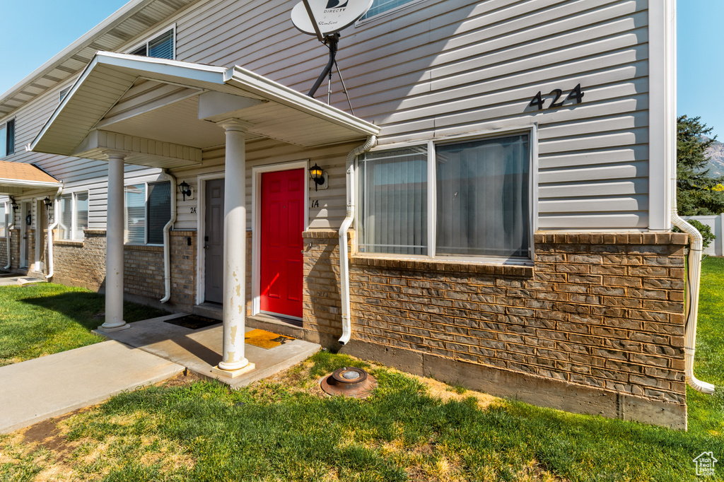 View of exterior entry with a yard